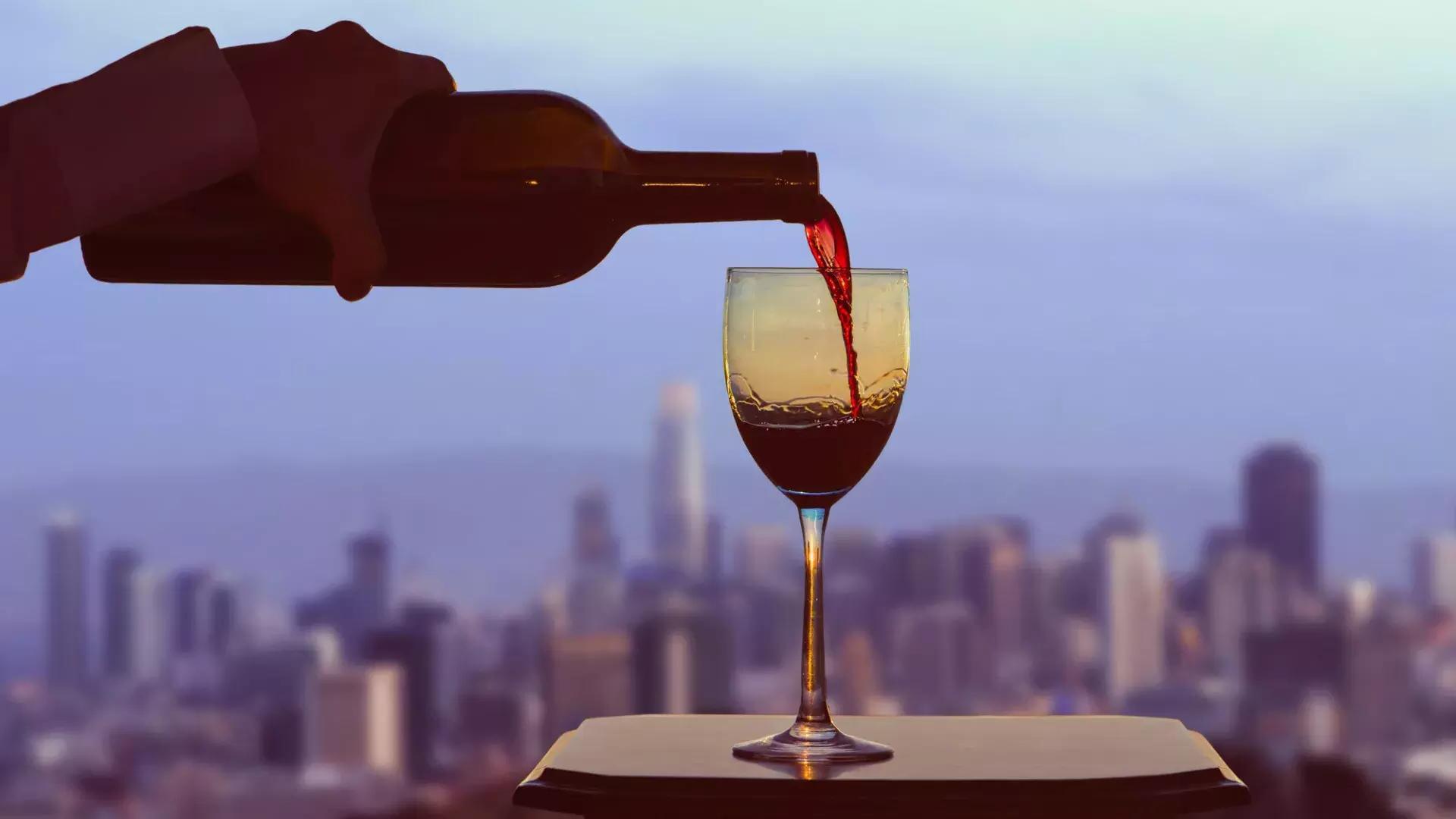 창밖으로 샌프란시스코 스카이라인이 보이는 레드와인 한 잔.