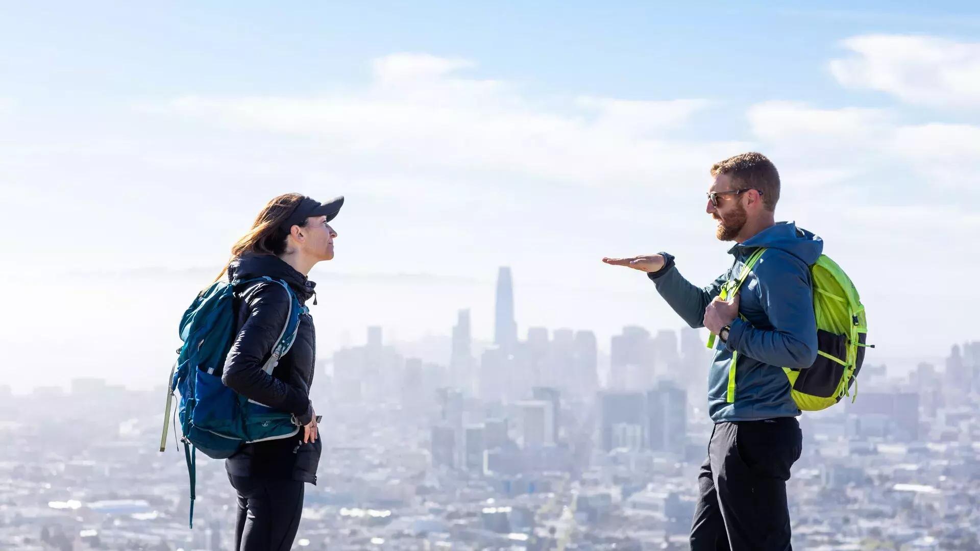 Hikers chatting with the San Francisco skyline in the distance