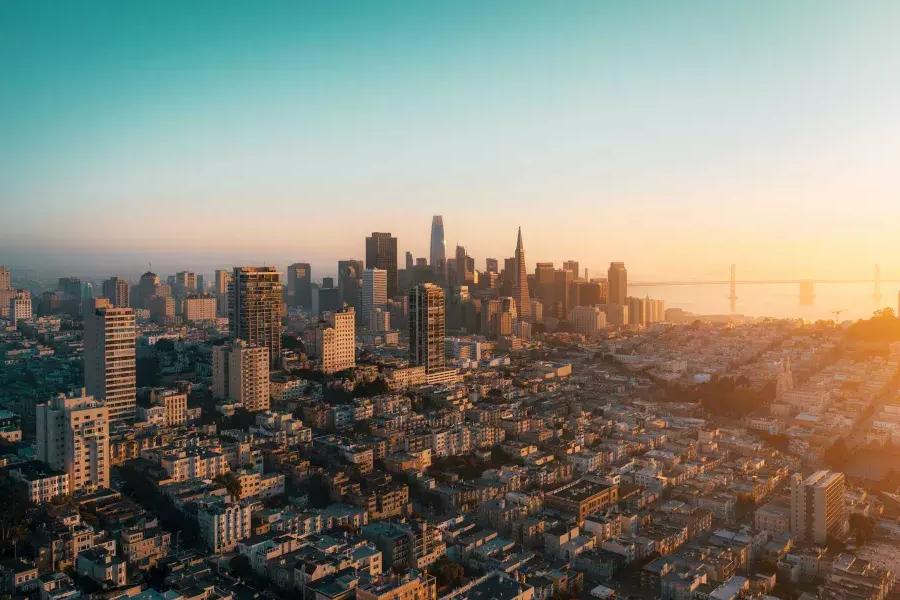 サンフランシスコのスカイラインが金色の光の中で上空から見えます。