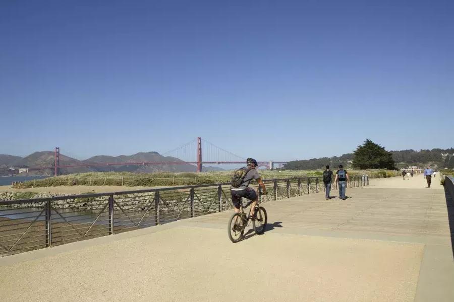 Ein Mann fährt mit dem Fahrrad einen Wanderweg am Crissy Field entlang. San Francisco, Kalifornien.