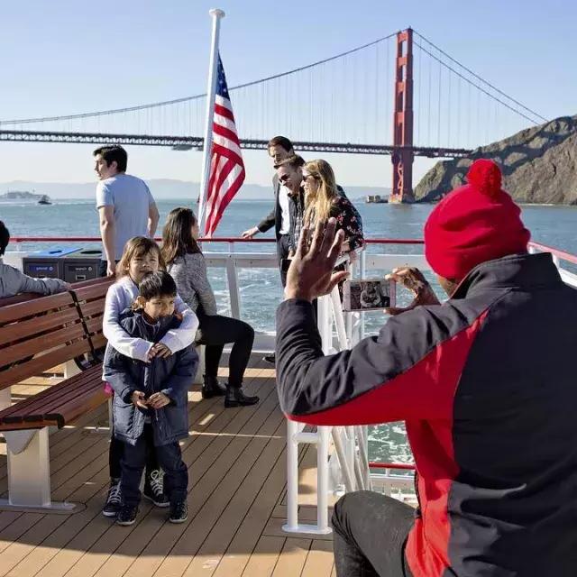 Una familia disfruta de un crucero por la bahía, pasando por el puente Golden Gate.
