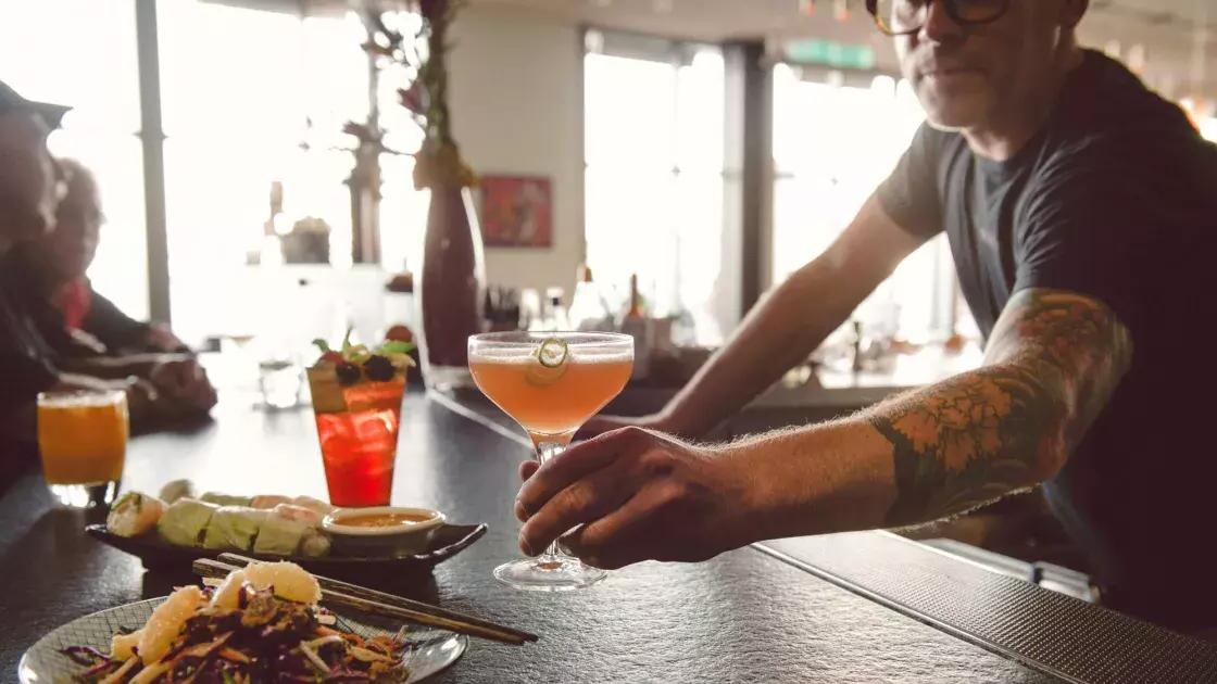 在贝博体彩app的一家酒吧里，调酒师为顾客提供鸡尾酒.